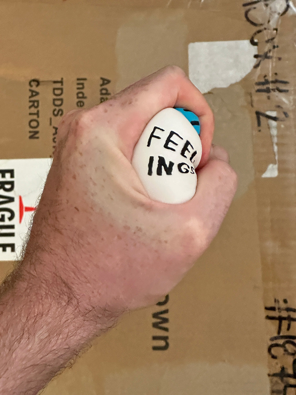 Hand squeezing the Feelings Jar Stress Toy by Adam JK