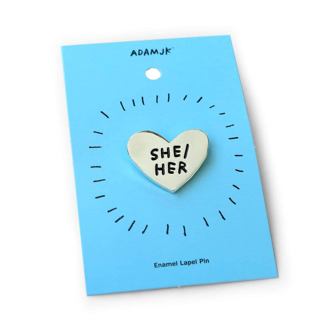 Pronoun Pins by Adam JK – Silver heart reads SHE/HER